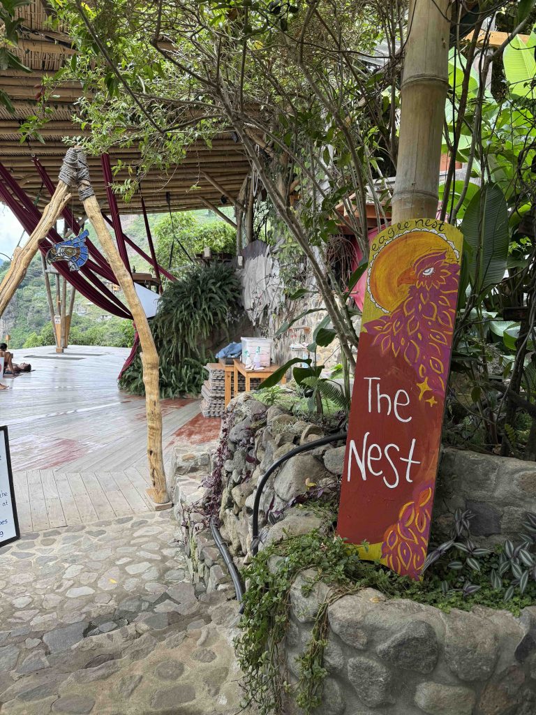 Entrance sign to Eagle’s Nest yoga shala in San Marcos with bamboo and plants around the platform.