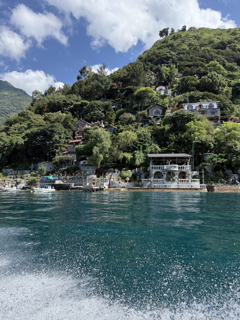 Colorful lakeside villas on steep green hillside above Lake Atitlán