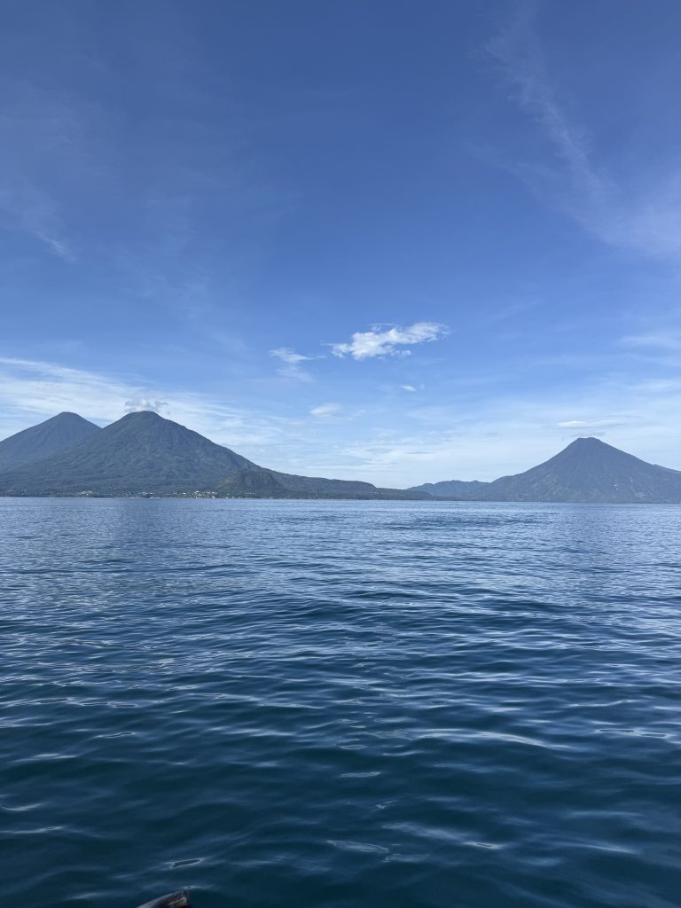 Wide view of Lake Atitlán with two volcanoes under a clear blue sky