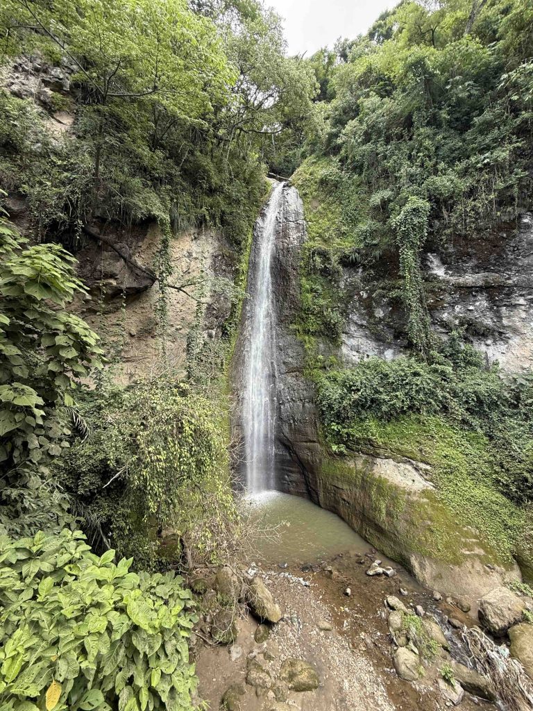Tall jungle waterfall and small pool on the hiking trail at Reserva Natural Atitlán in Panajachel