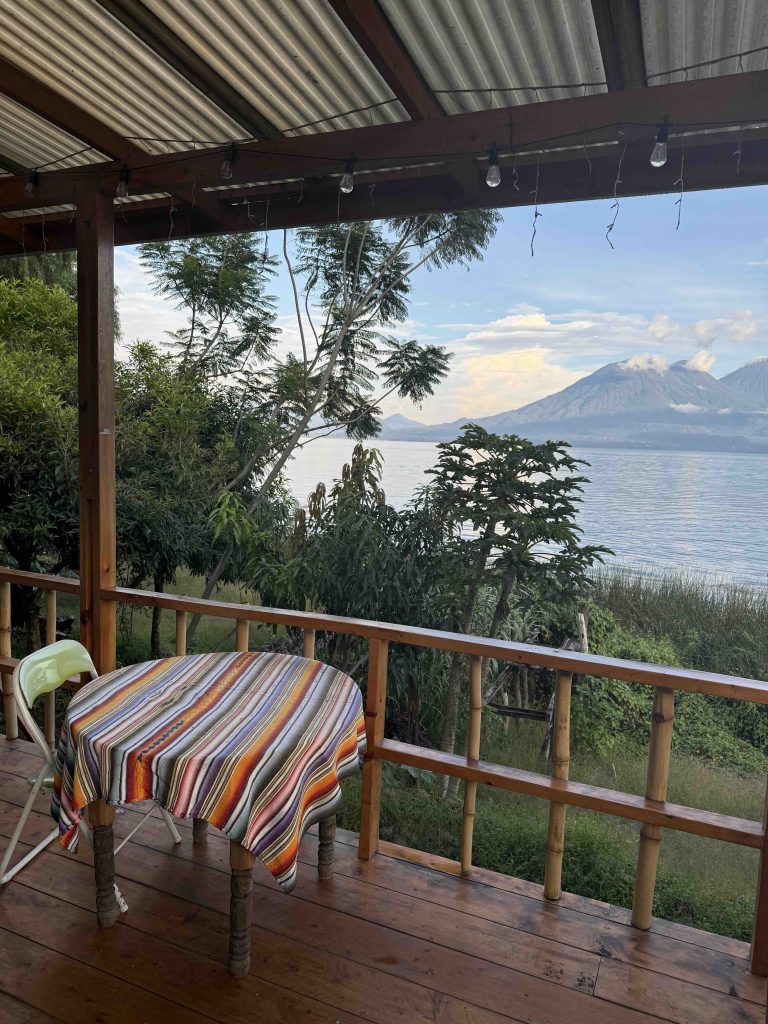 Rustic wooden porch with a colorful tablecloth and lake view in San Marcos La Laguna, Guatemala.