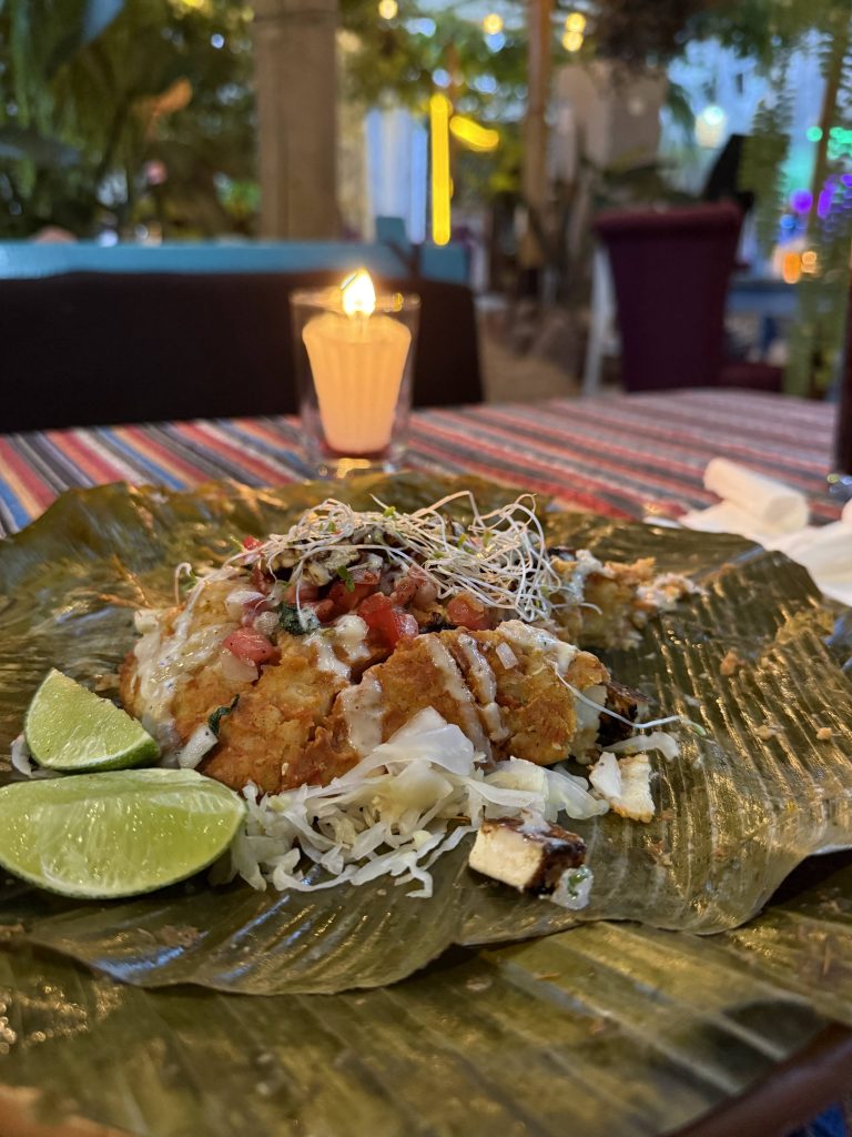 Traditional Guatemalan dinner served on a banana leaf with lime wedges at a cozy restaurant in San Marcos.