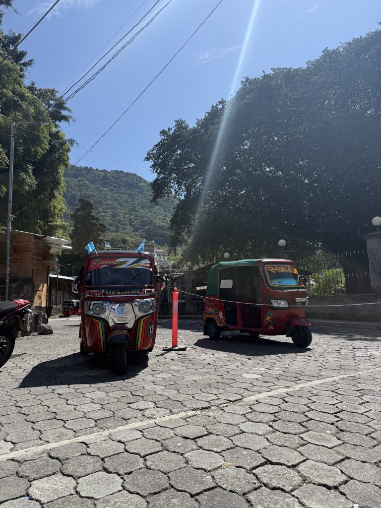 Colorful tuk-tuks waiting on a sunny street in San Marcos La Laguna, Lake Atitlán