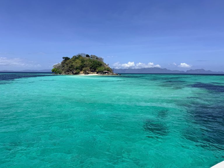 Small tropical island surrounded by clear turquoise water on the Sea Expedition from El Nido to Coron, Philippines.