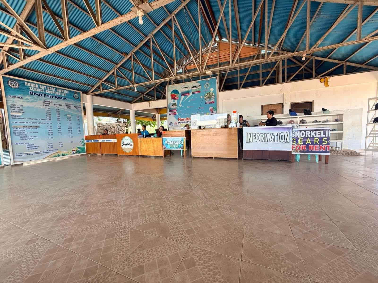 Honda Bay Wharf booking area in Puerto Princesa with boat fare rates, information desk, and snorkeling gear rental counter