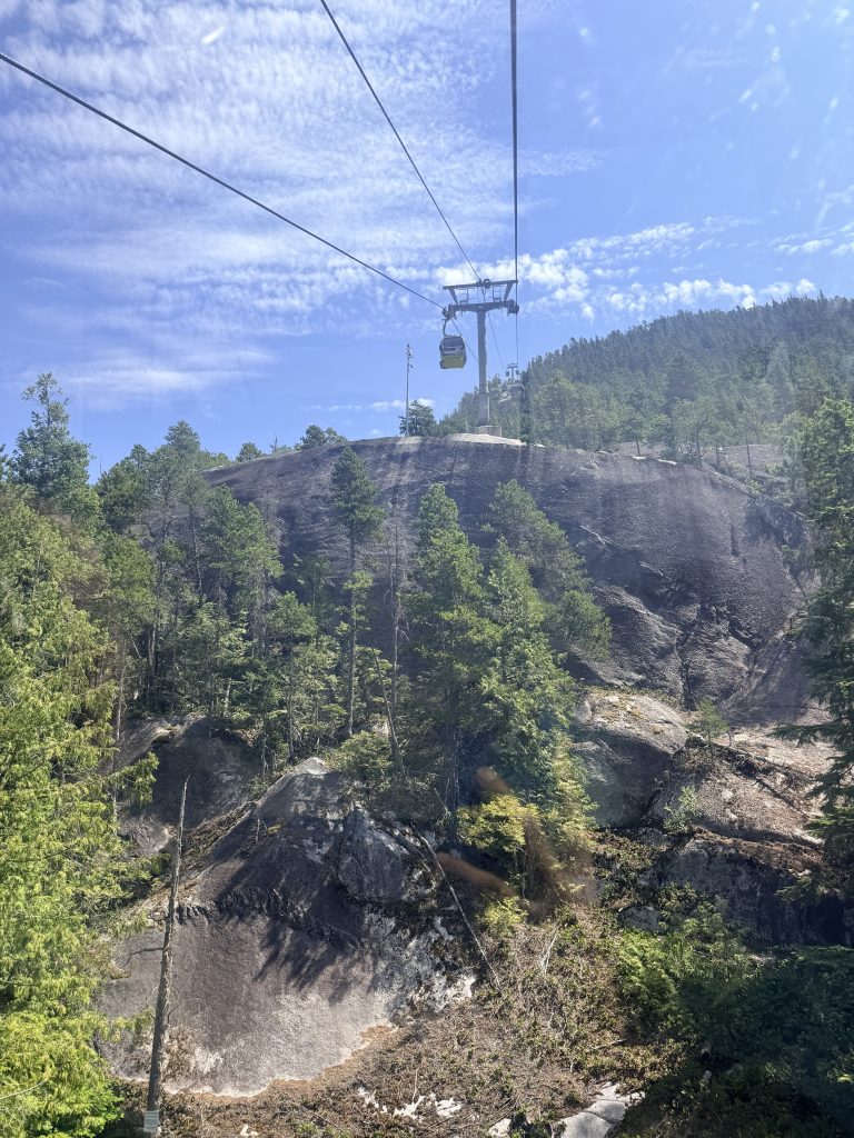 Sea to Sky Gondola ascending over forested mountains in Squamish