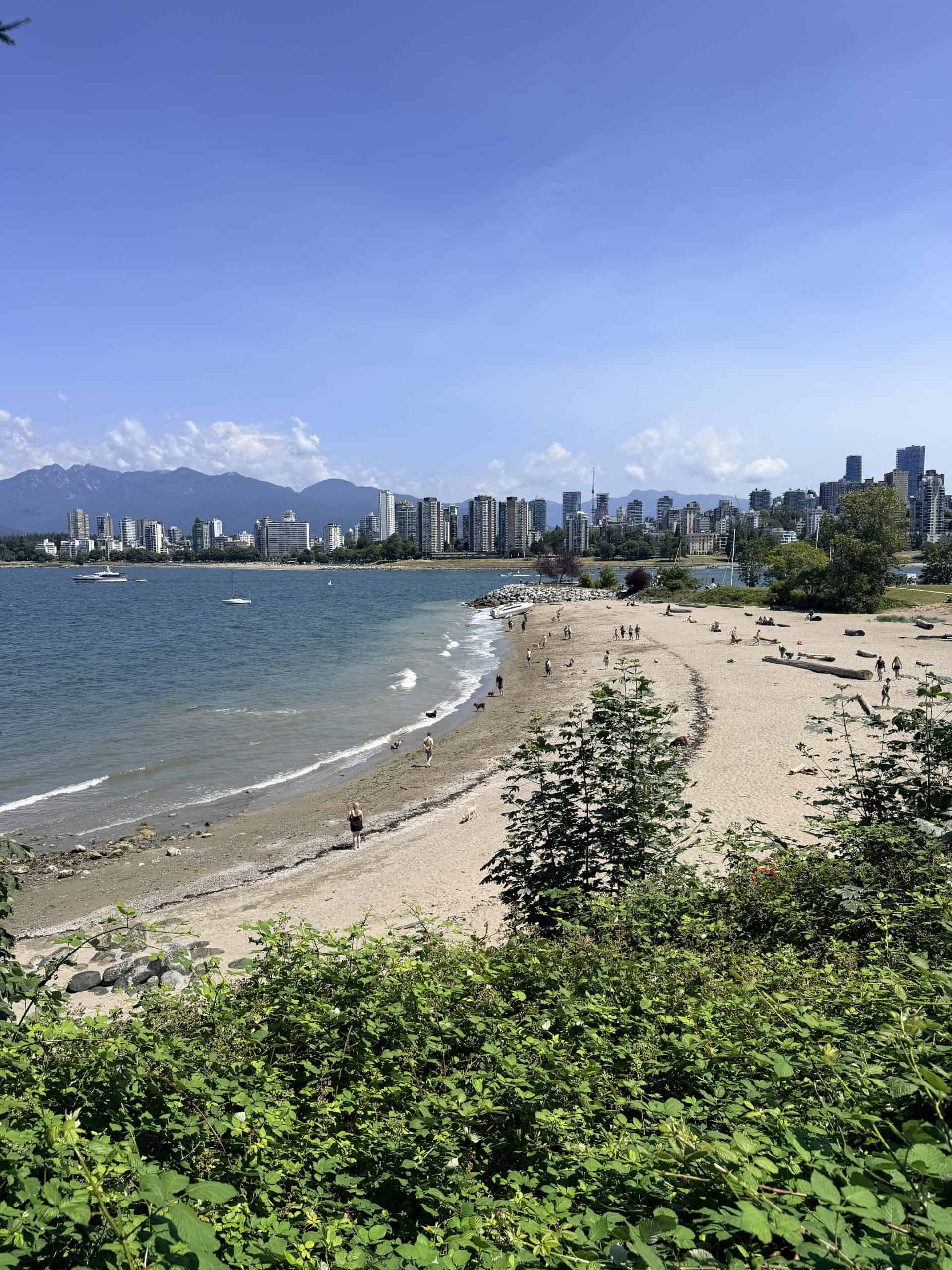 View from Kitsilano Beach across the water toward the Vancouver skyline and North Shore Mountains.