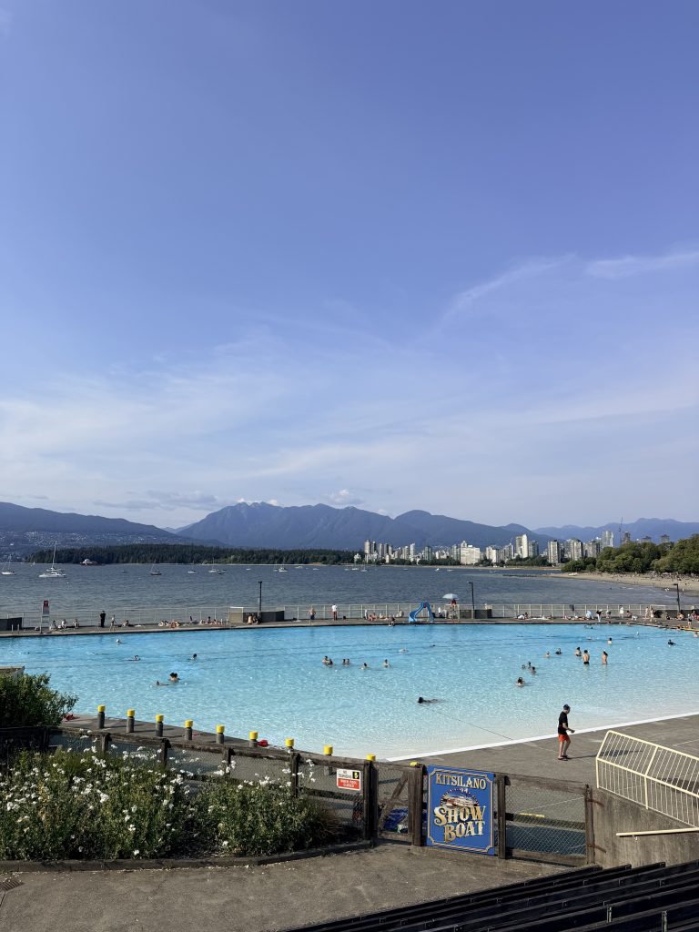 Kitsilano Pool overlooking English Bay with the Vancouver skyline and North Shore Mountains in the distance.