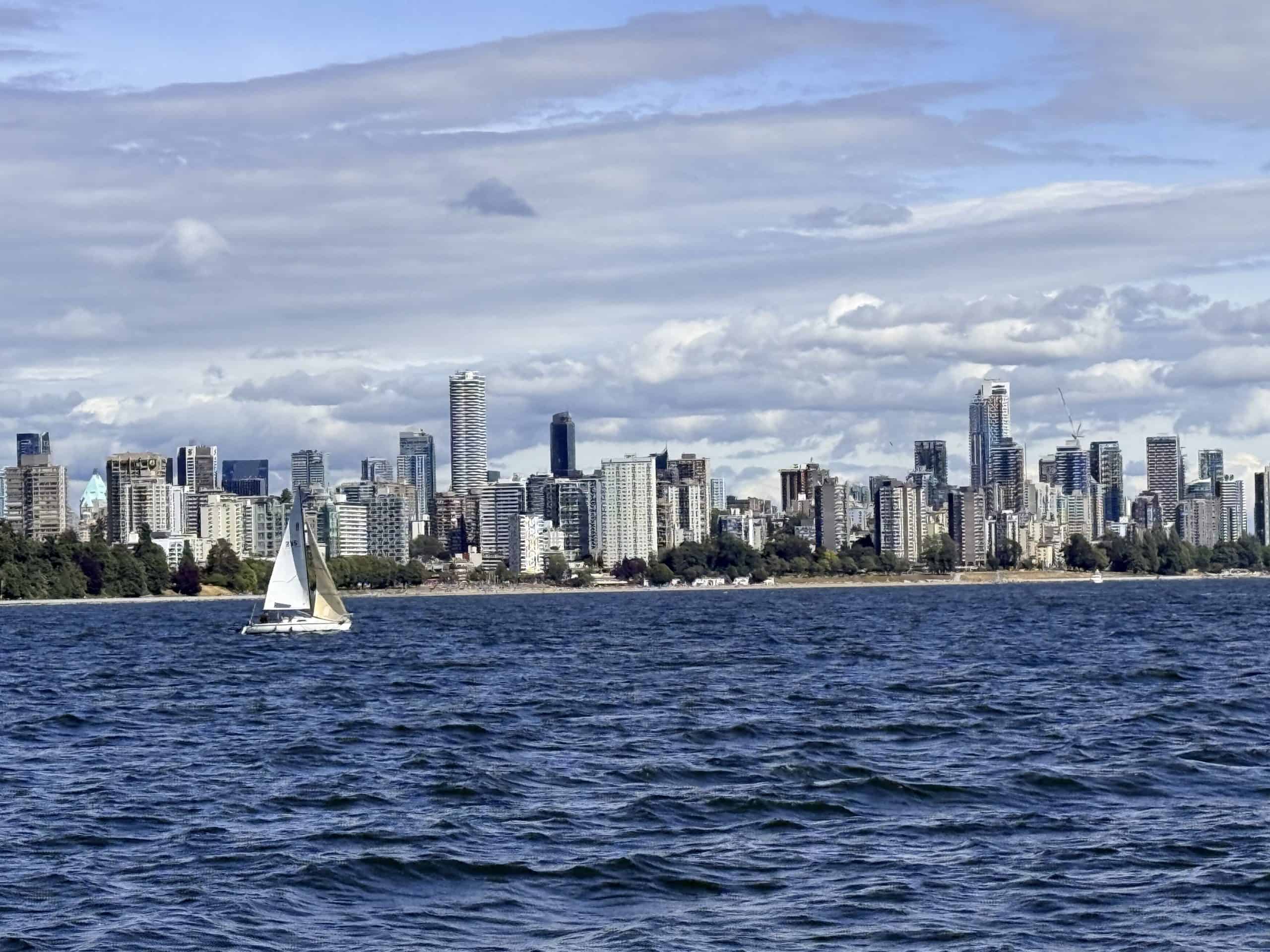 Vancouver skyline and a sailboat viewed from the water while sailing on English Bay.