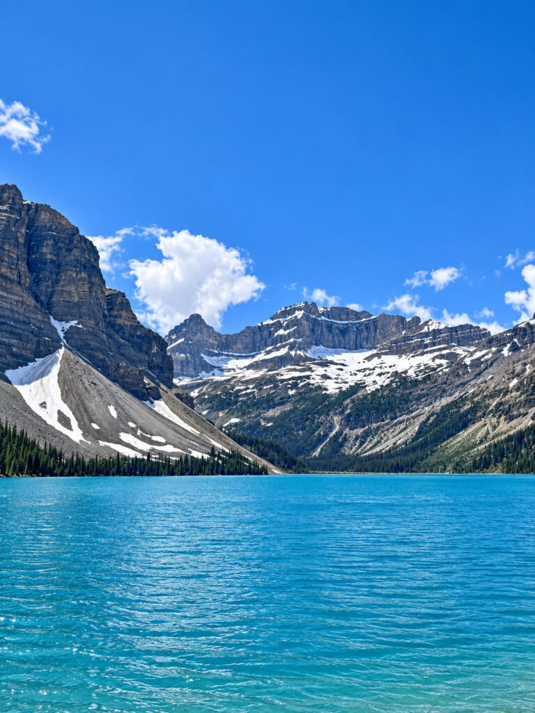 Turquoise Bow Lake surrounded by snow-capped mountains along the Icefields Parkway in Banff National Park.