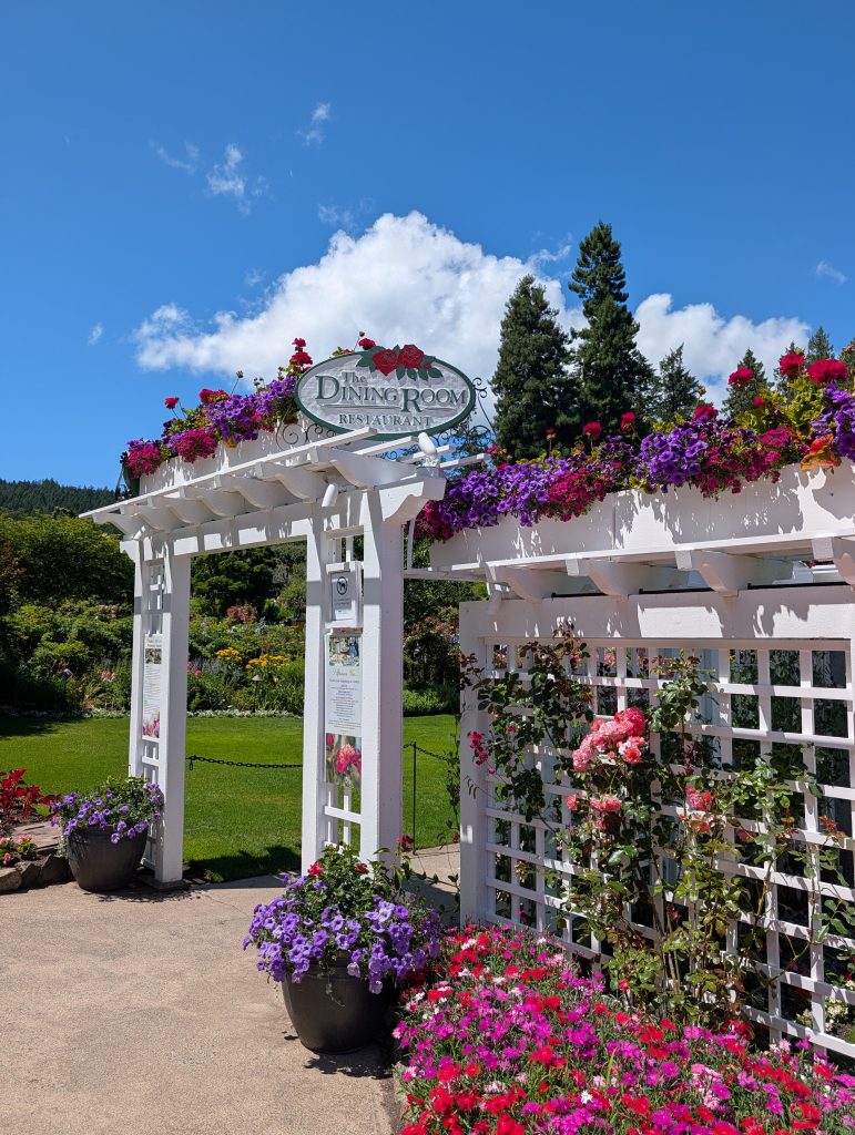 Flower-covered white entrance to The Dining Room Restaurant at Butchart Gardens near Victoria, BC.