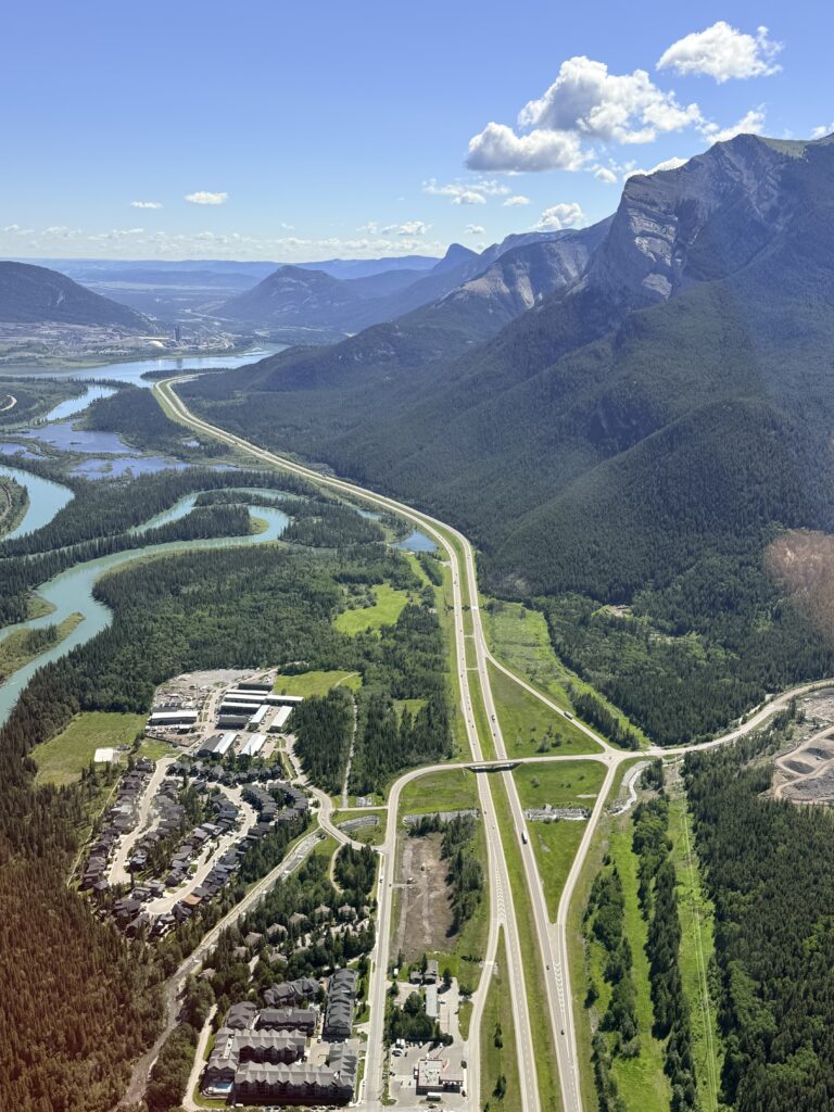 Aerial view over Canmore, the Bow River and Trans-Canada Highway during a helicopter flight in Alberta.