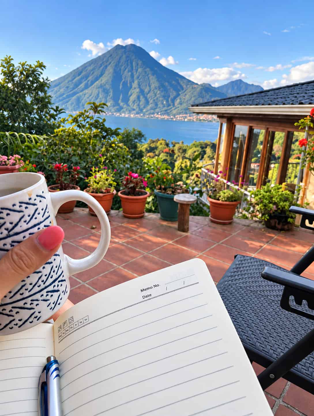 Travel planning with a notebook and coffee overlooking Lake Atitlán in Guatemala