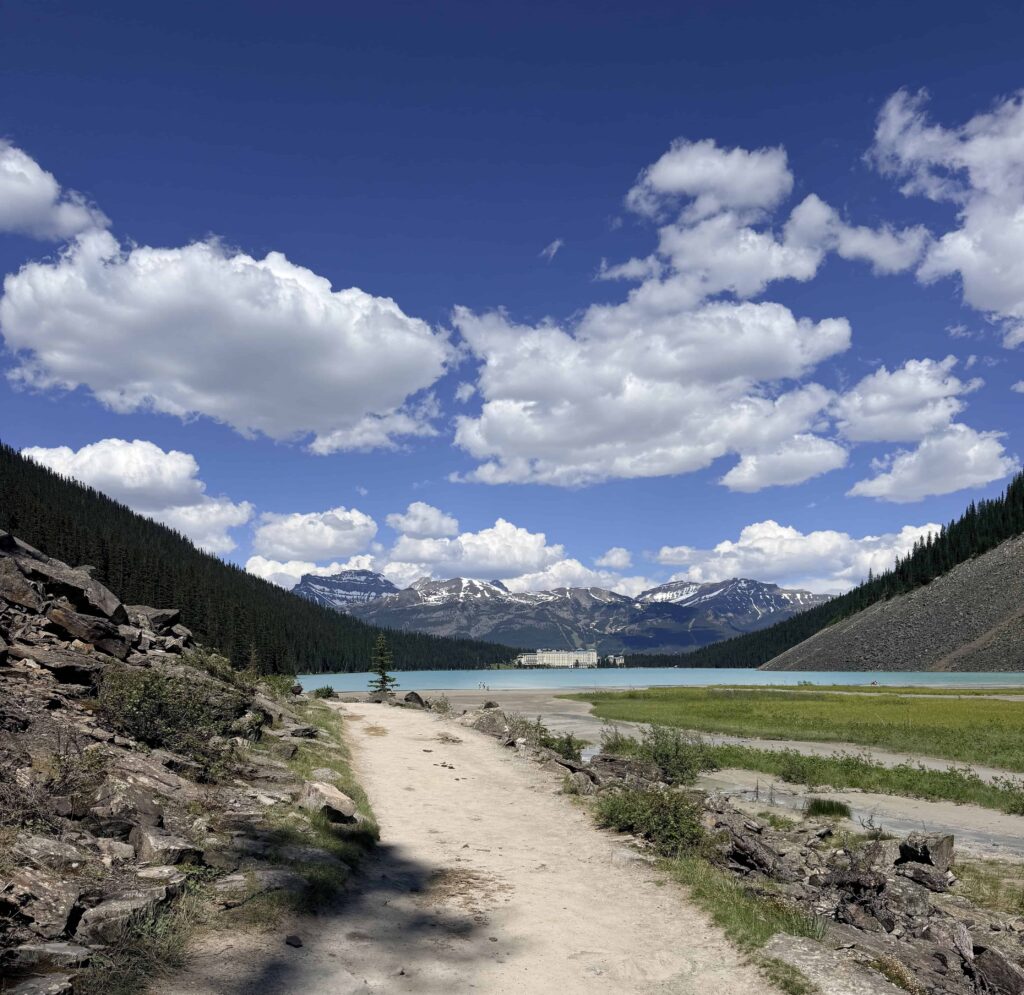 Lakeshore hiking trail leading toward Lake Louise and the Fairmont Chateau Lake Louise in Banff National Park.