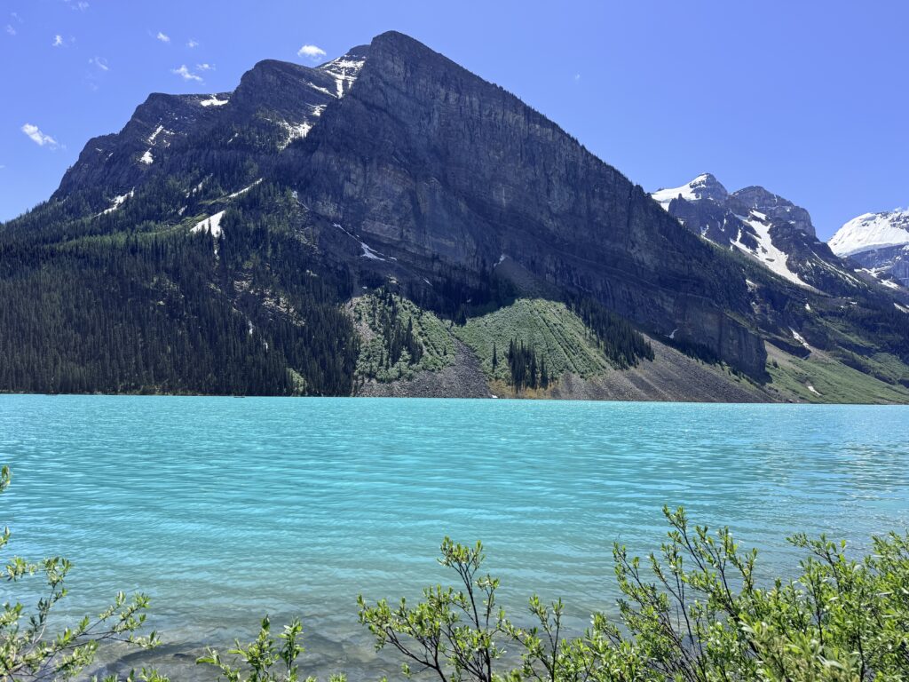 Turquoise water at Lake Louise surrounded by steep Rocky Mountain peaks in Banff National Park.
