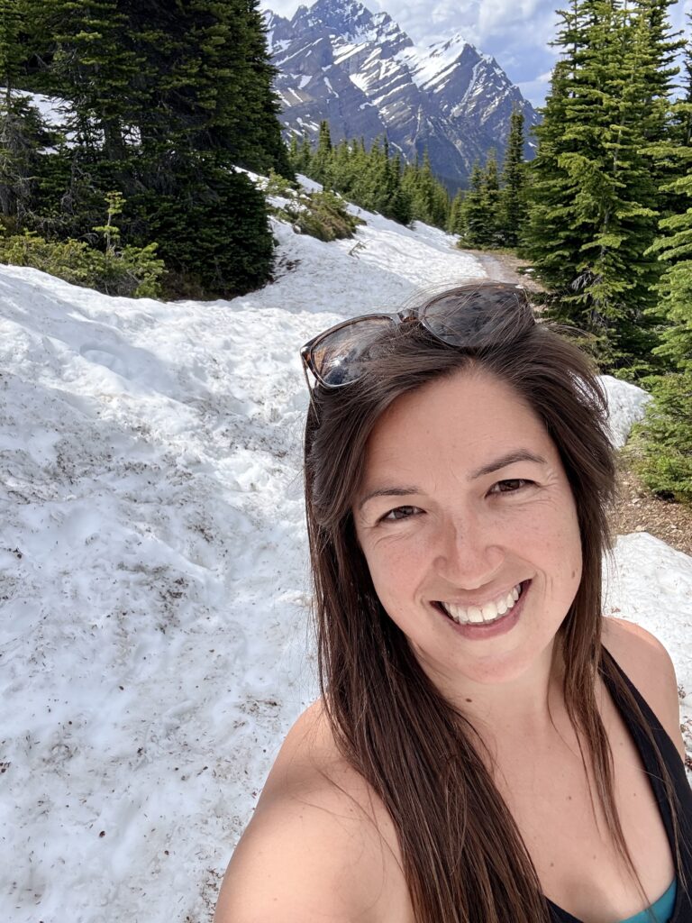 Snow-covered trail near the Peyto Lake viewpoint with dramatic Rocky Mountain peaks in the background.