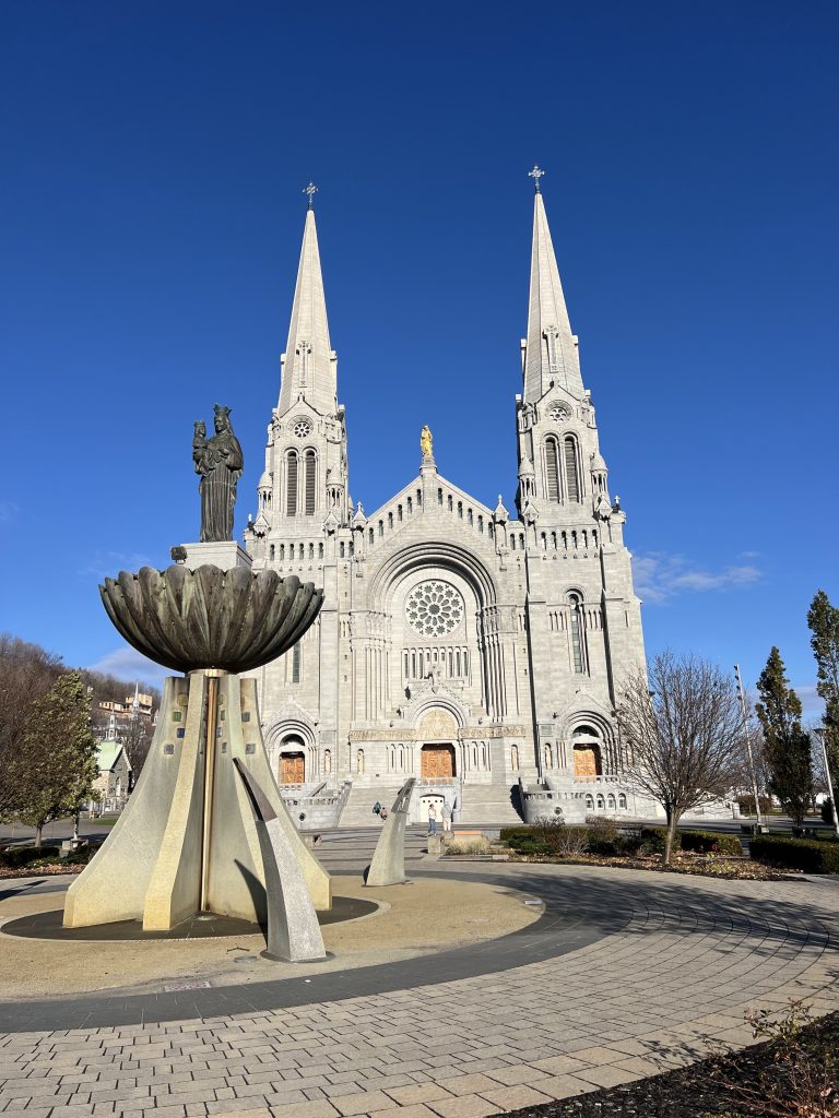 Basilica of Sainte-Anne-de-Beaupré near Quebec City with its twin spires and fountain in the foreground.