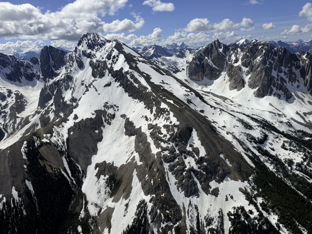 Snow-covered mountain ridges viewed from a helicopter flight over the Canadian Rockies.