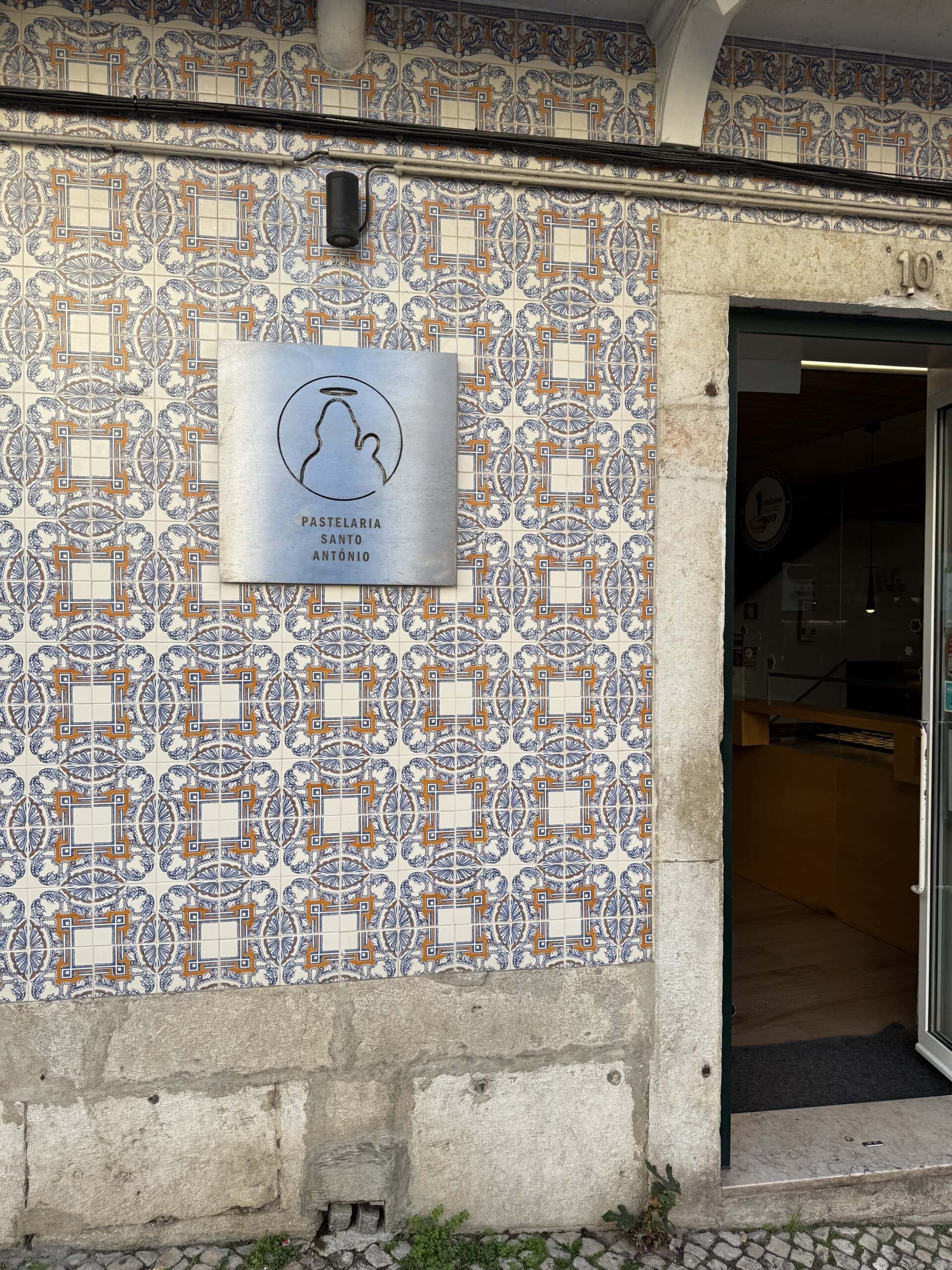 Traditional blue, white and orange Portuguese azulejo tiles decorating the façade of Pastelaria Santo António near São Jorge Castle in Lisbon.