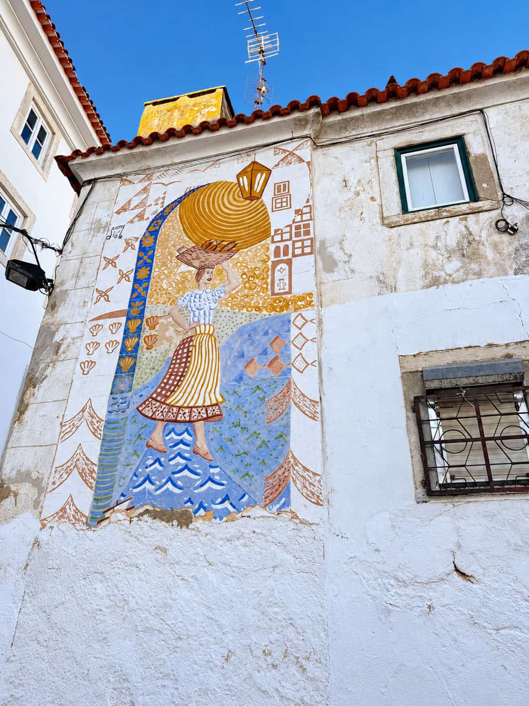 Traditional Portuguese-inspired street art mural decorating a wall in Alfama, Lisbon.