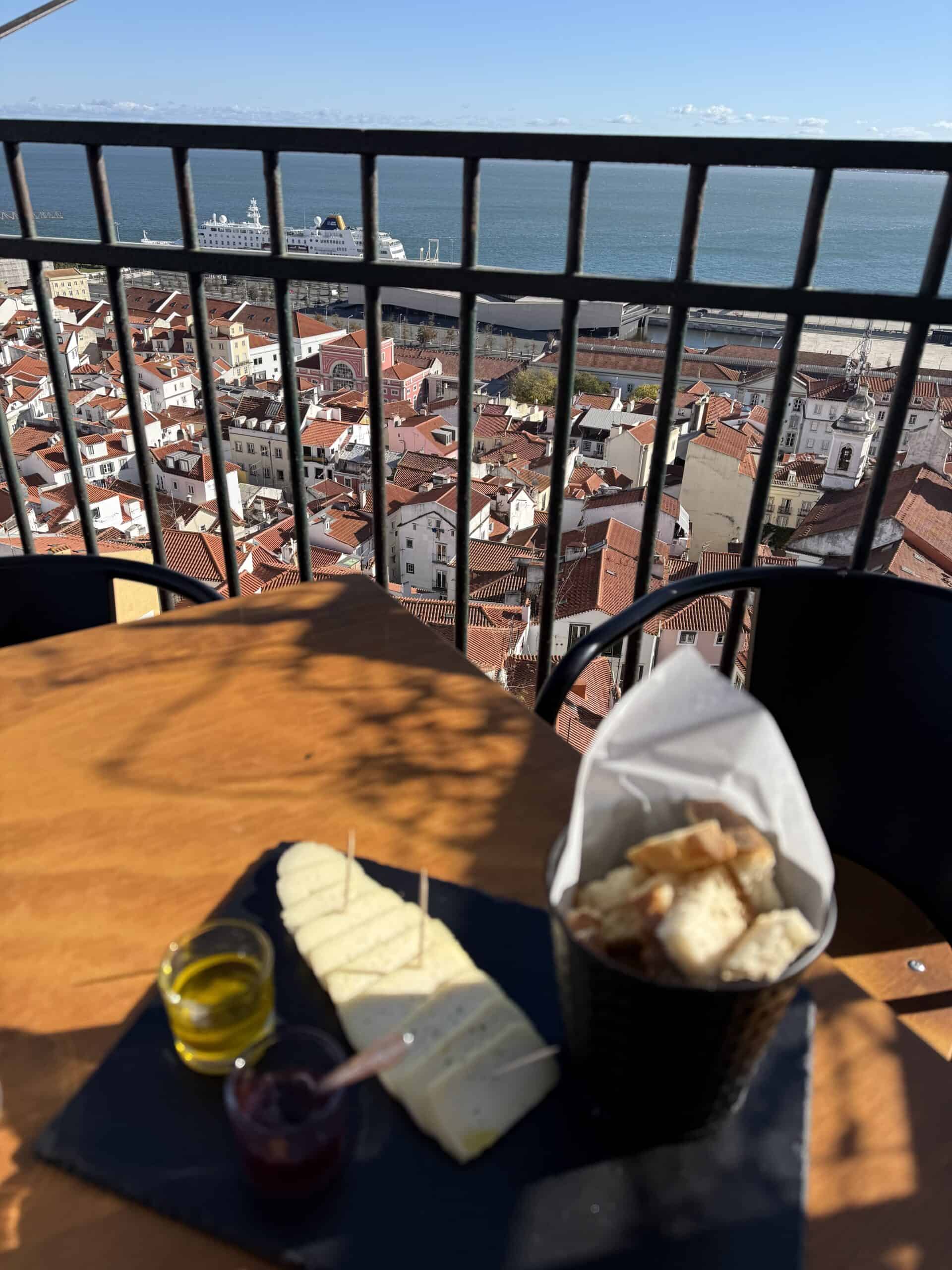 Cheese platter and bread served at Bar Terraço de Santa Luzia, overlooking Alfama's red rooftops and the Tagus River.