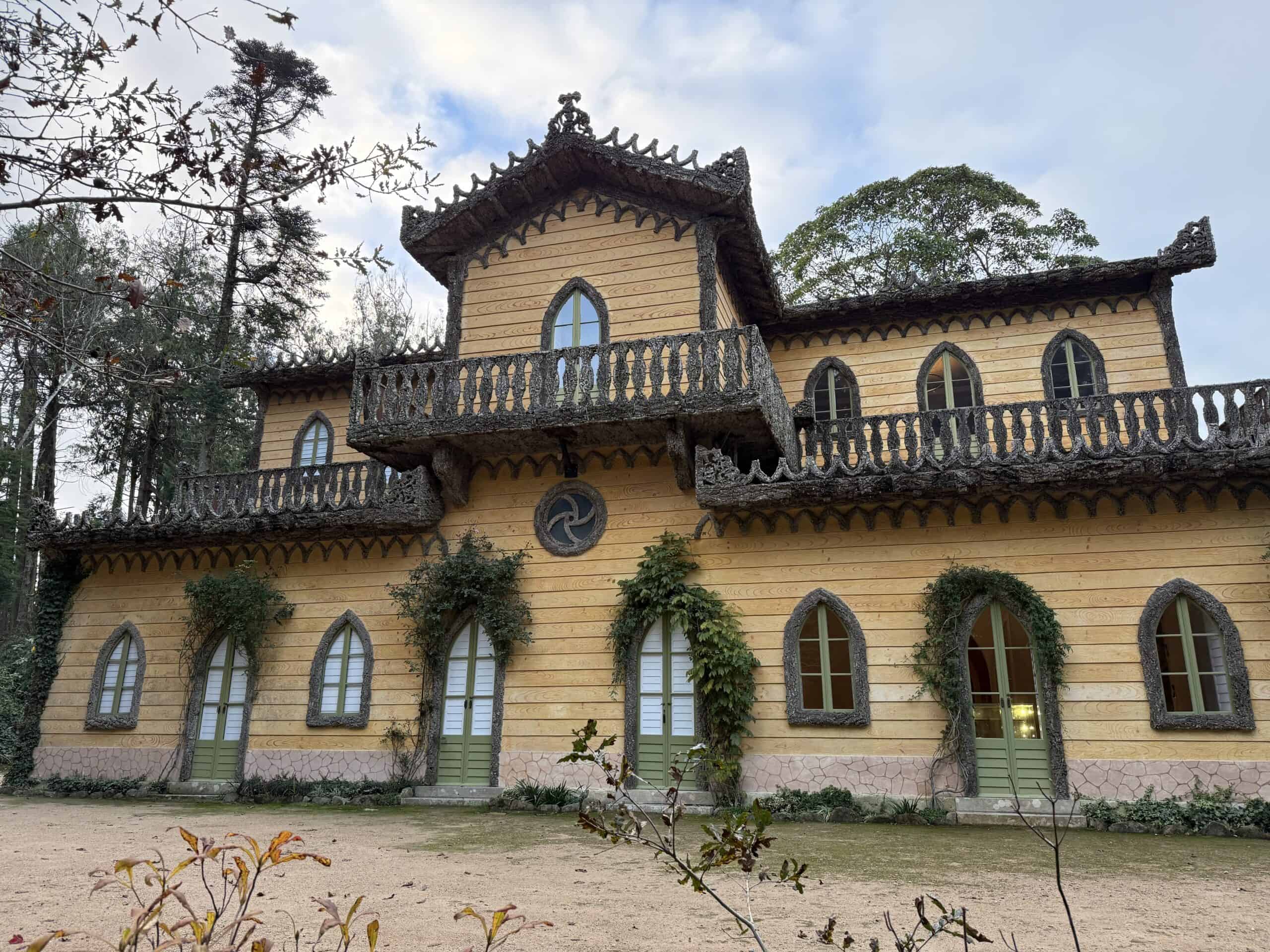 Exterior of the Chalet of the Countess of Edla in Sintra, with yellow walls, pointed windows, and decorative balconies.