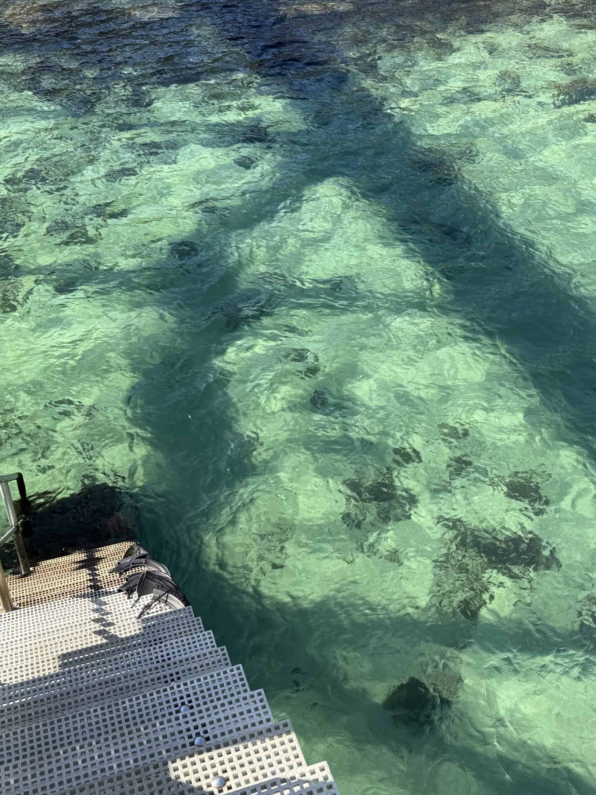 Crystal-clear turquoise water along the coast of Arrábida Natural Park, Portugal
