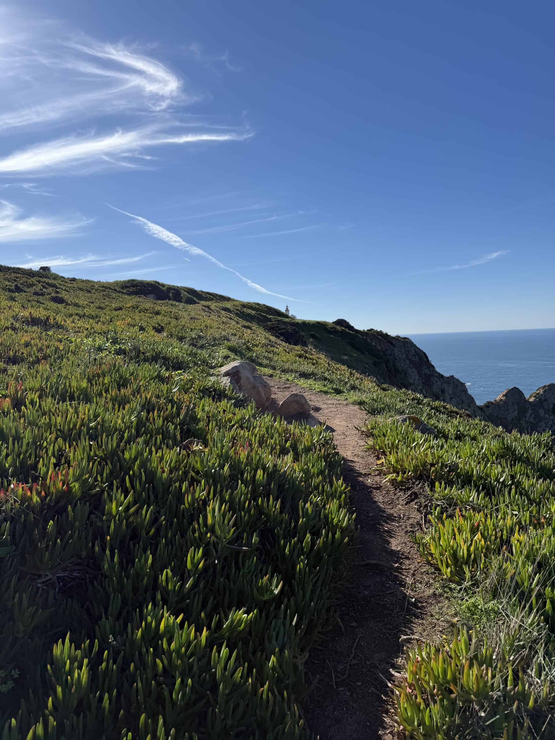 Coastal hiking path leading towards Cabo da Roca lighthouse in Portugal