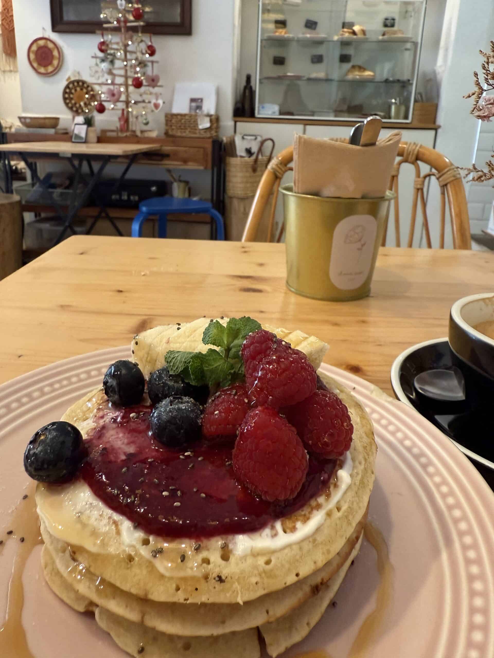 Pancakes topped with berries and banana at Dear Rose Café in Ericeira, Portugal.