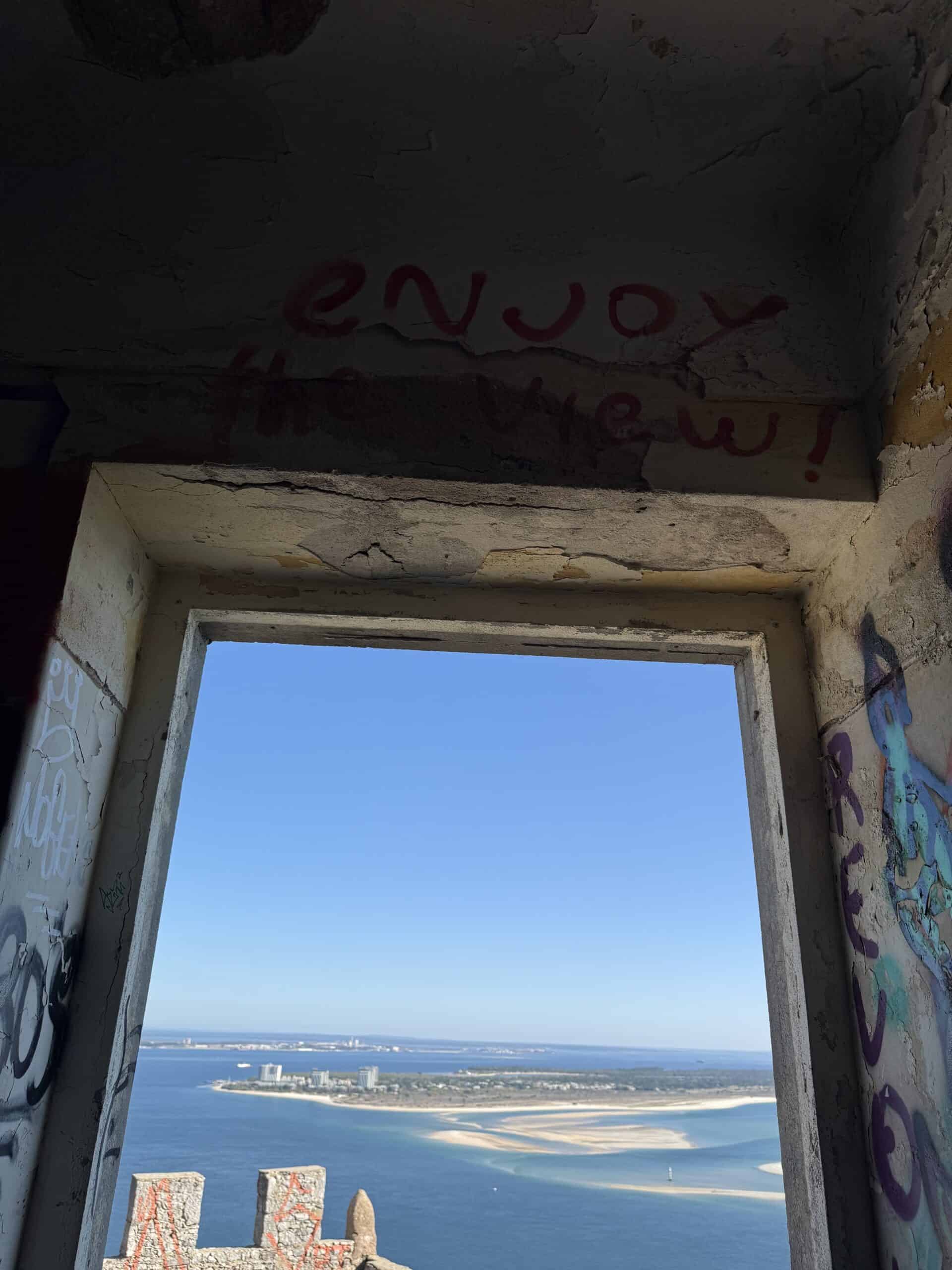 View of the Tróia Peninsula and Sado Estuary through a stone window at Fortaleza de São Filipe in Setúbal, Portugal