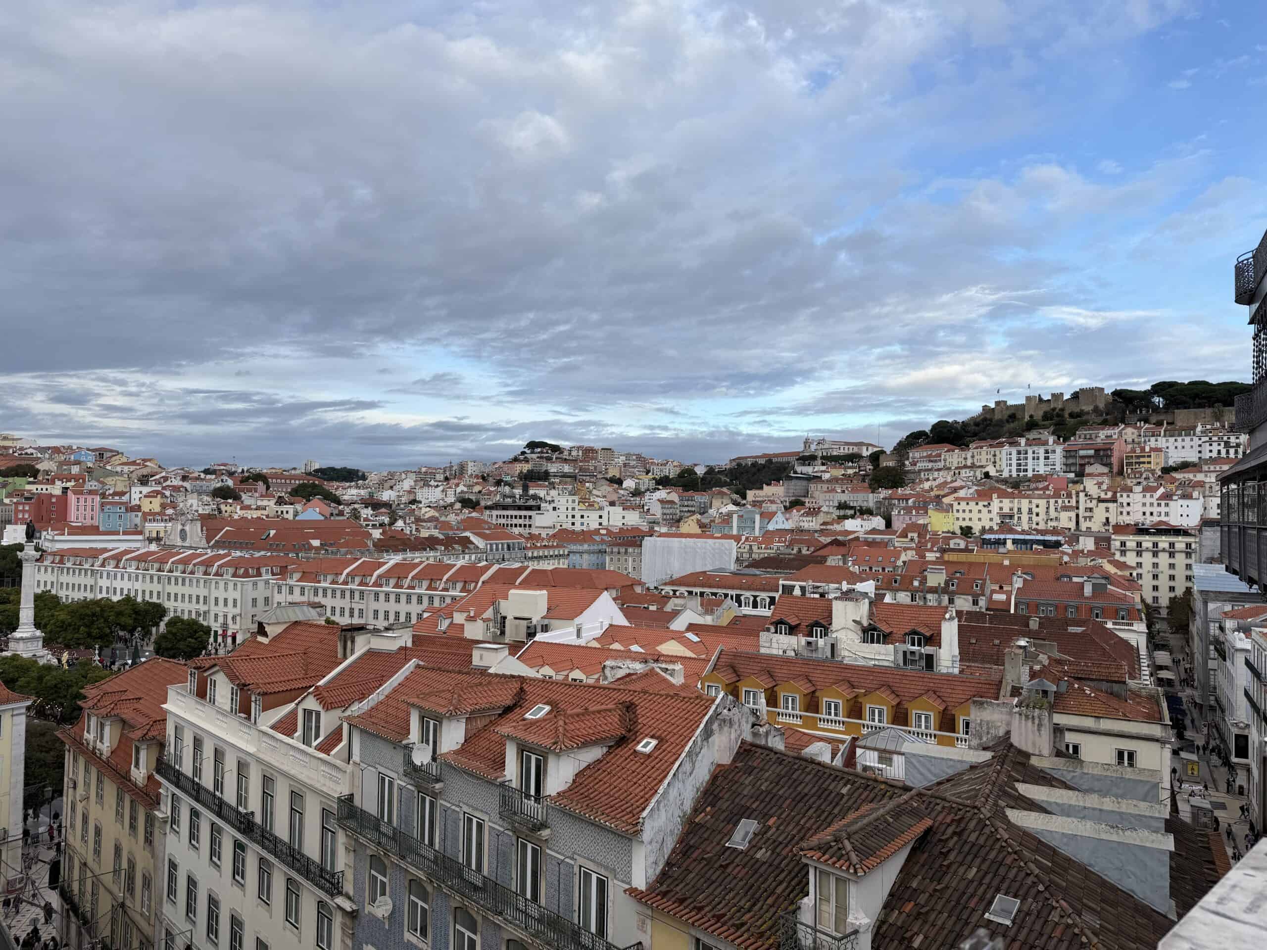 Panoramic view of Lisbon's red rooftops, colourful buildings and São Jorge Castle from Miradouro de São Pedro de Alcântara.