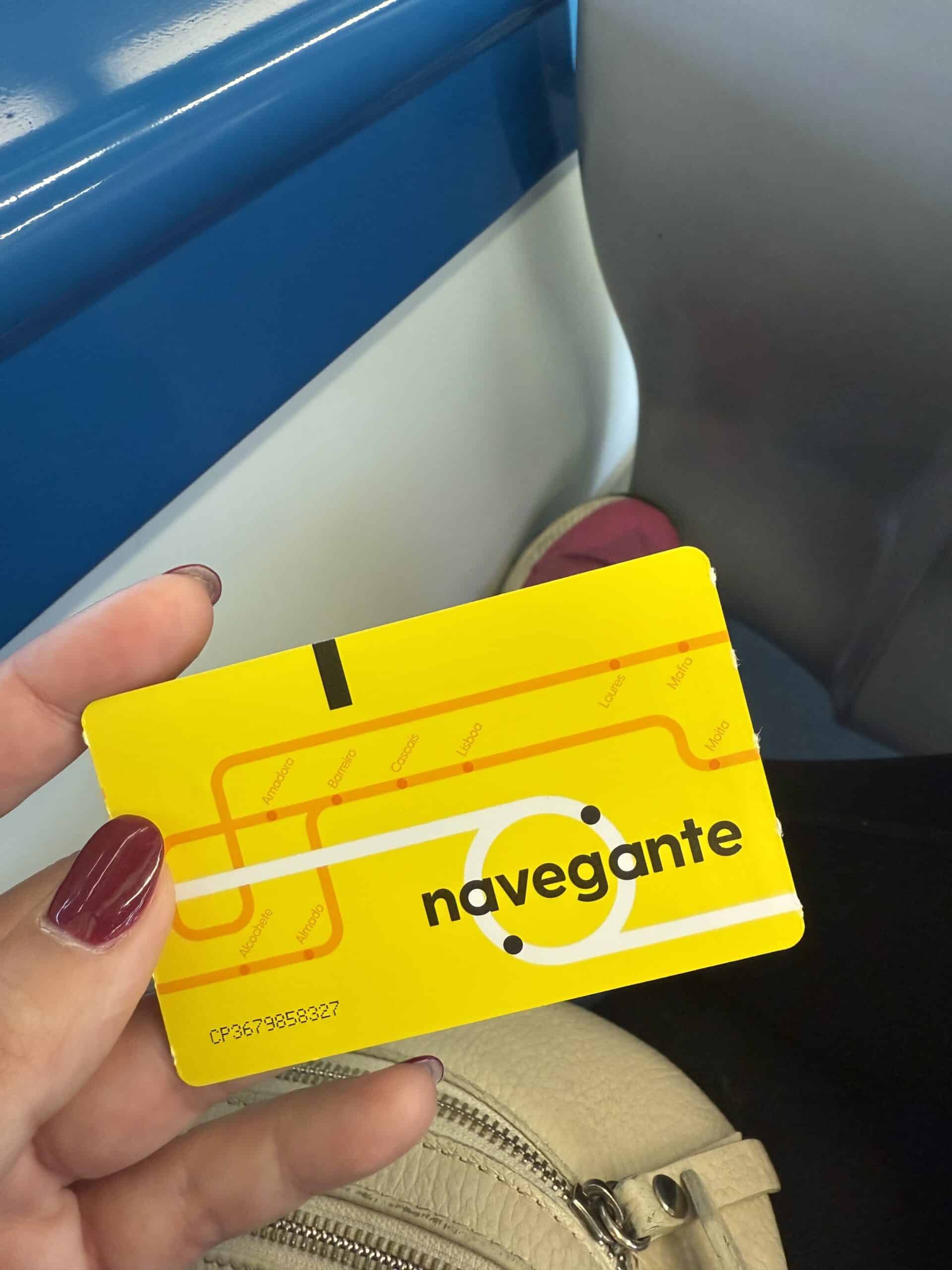 Hand holding a yellow Navegante public transport card in Lisbon.