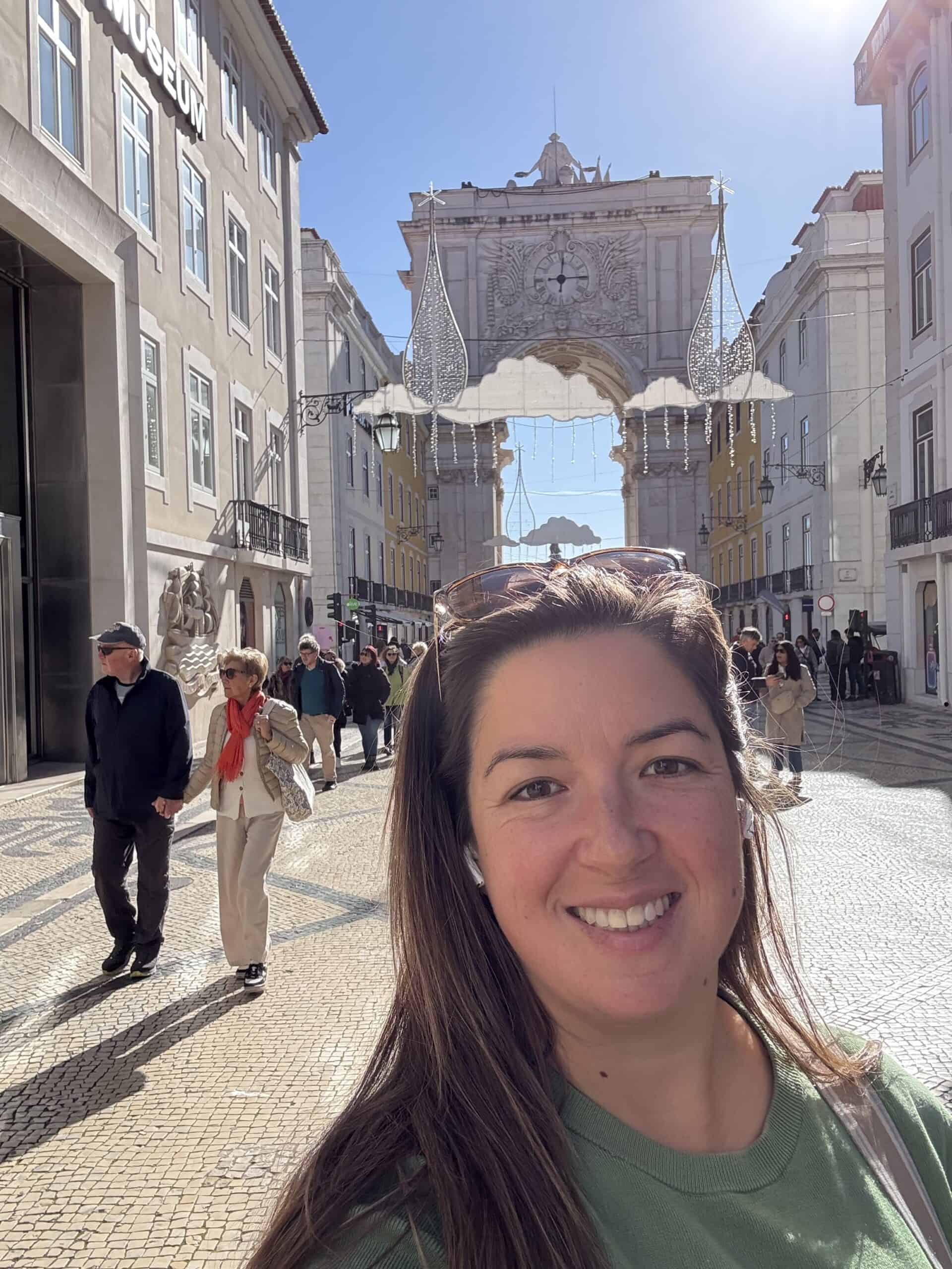 Traveller on Rua Augusta in Lisbon’s Baixa neighbourhood, with the arch and Christmas decorations in the background.