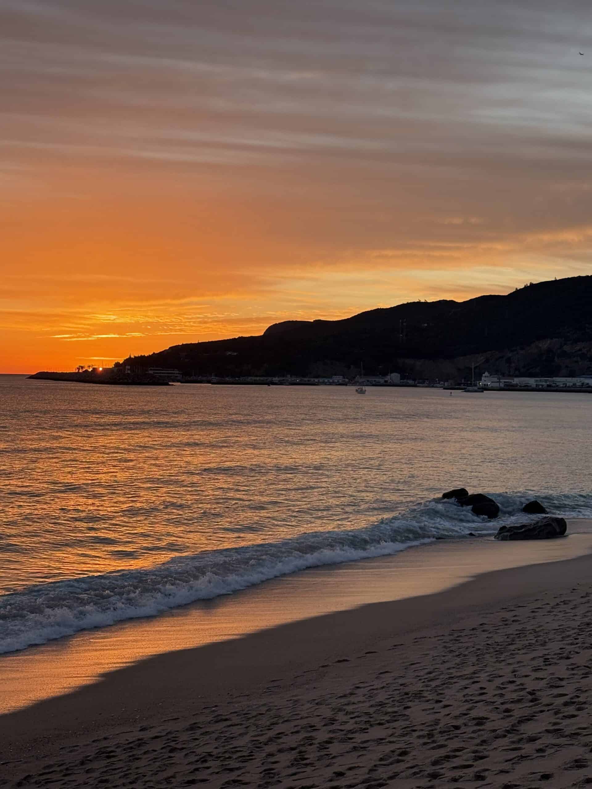 Orange sunset over the beach and Atlantic coast in Sesimbra, Portugal