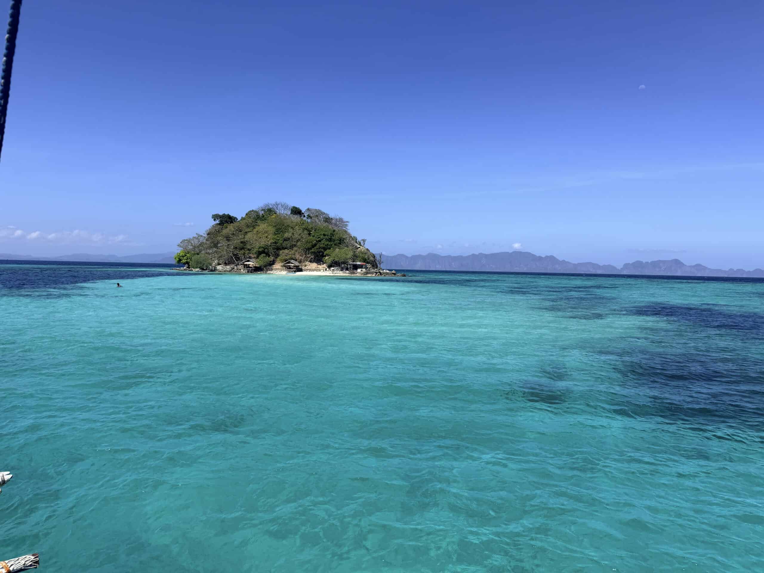 Tiny tropical island surrounded by turquoise water during the El Nido to Coron expedition in Palawan, Philippines
