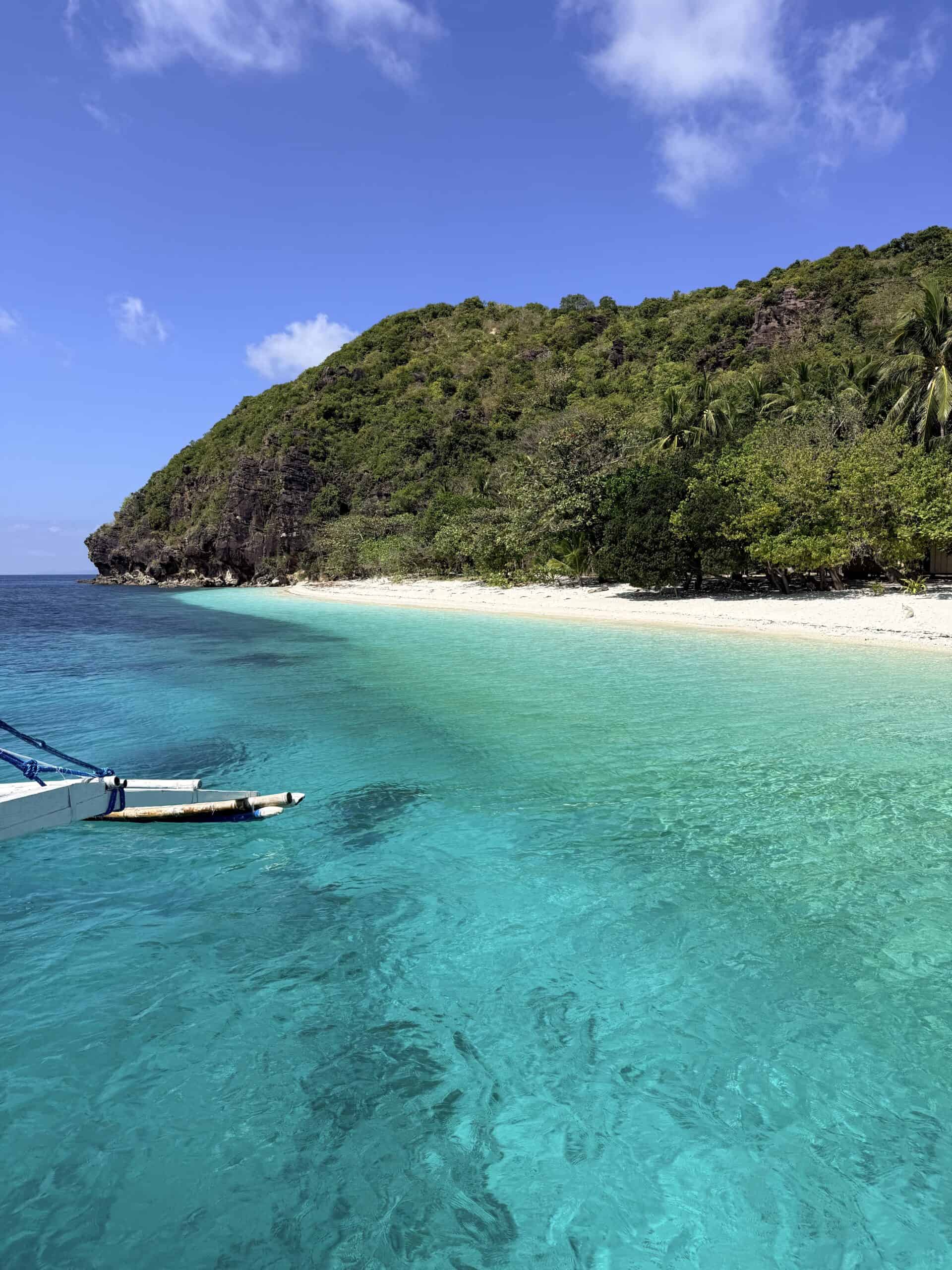 Turquoise water surrounding a remote tropical island in Palawan during an El Nido to Coron boat expedition