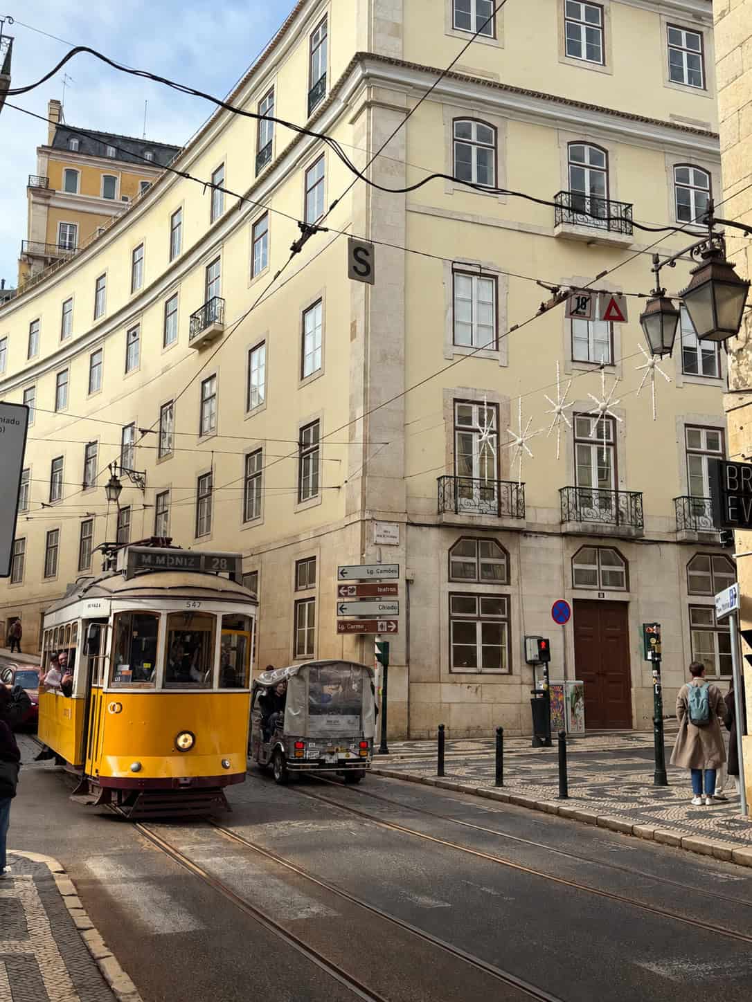 Yellow Tram 28 travelling through the historic Chiado neighbourhood in Lisbon, Portugal.
